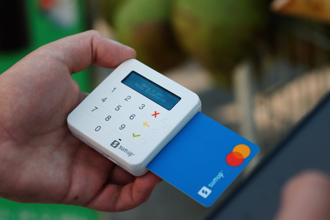 a person holding a credit card and a cell phone