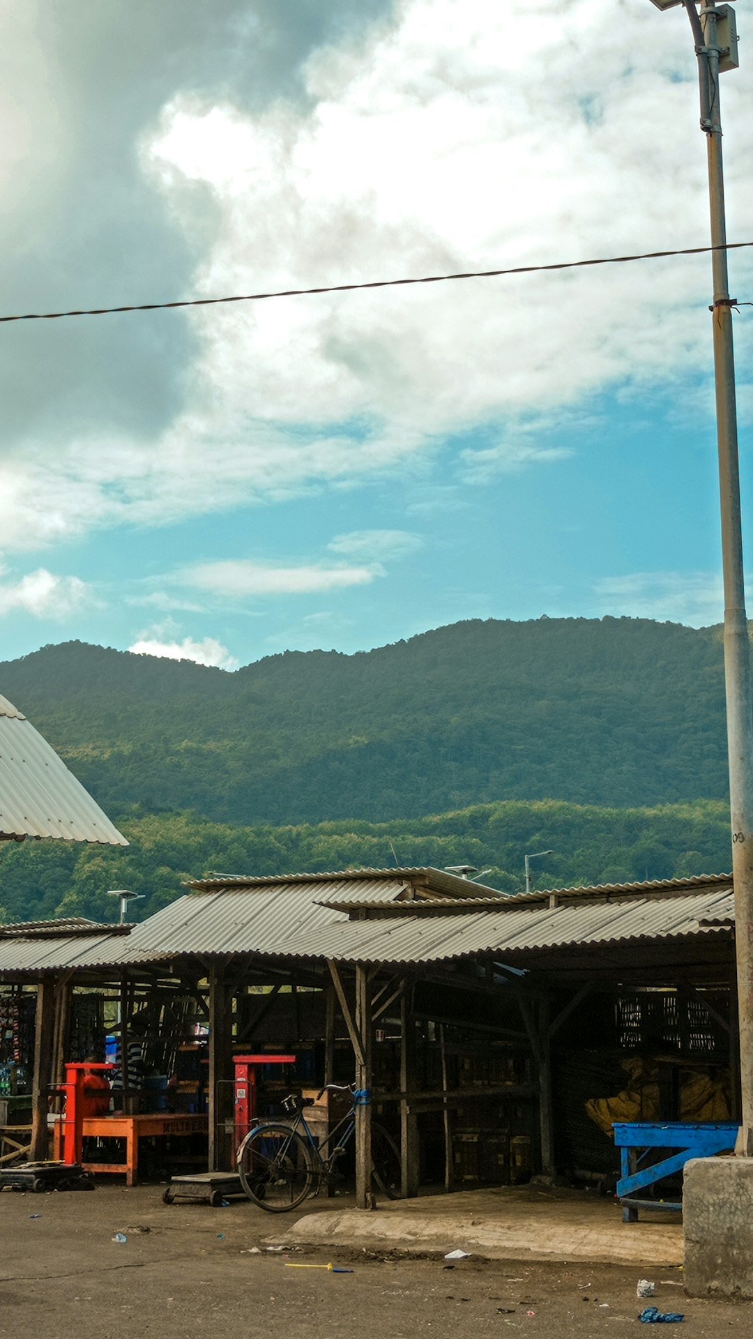 Shacks with mountains in the background under a blue sky.